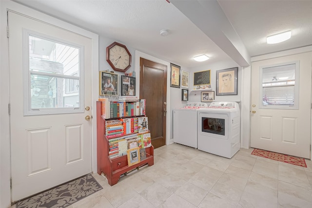 laundry room with washer and clothes dryer, light tile patterned flooring, and a textured ceiling