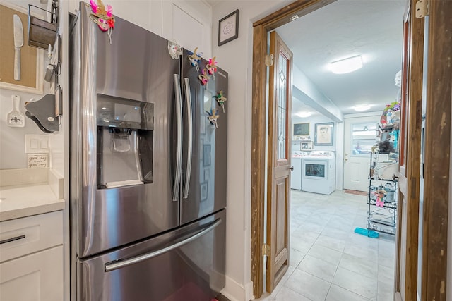 kitchen with white cabinetry, stainless steel fridge with ice dispenser, washer / clothes dryer, a textured ceiling, and light tile patterned floors