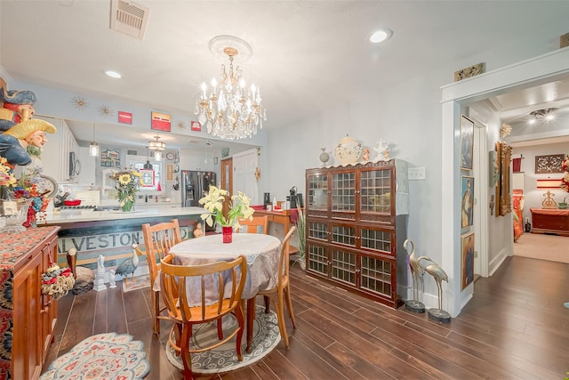 dining space featuring dark hardwood / wood-style flooring and an inviting chandelier