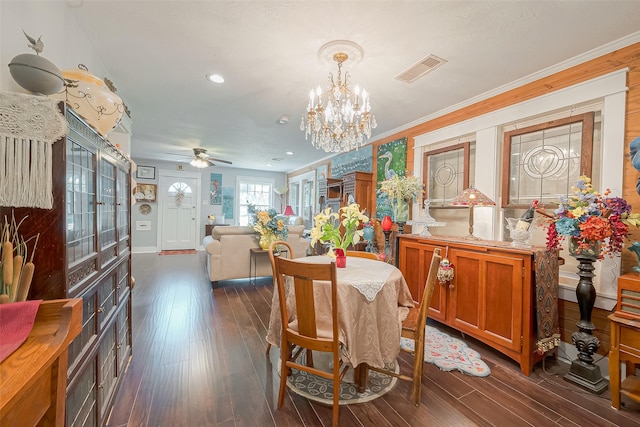 dining space with ceiling fan with notable chandelier, dark hardwood / wood-style flooring, and ornamental molding