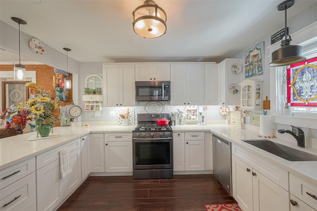 kitchen featuring dark hardwood / wood-style flooring, white cabinetry, sink, and appliances with stainless steel finishes