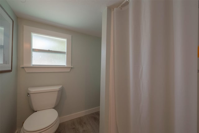 bathroom featuring wood-type flooring and toilet