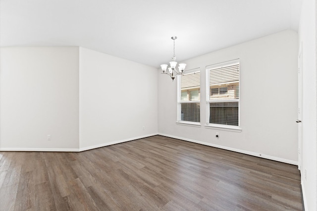 unfurnished room featuring dark hardwood / wood-style floors and a chandelier