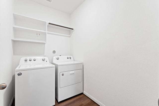 laundry room with washing machine and clothes dryer and dark hardwood / wood-style flooring