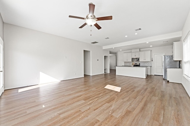 unfurnished living room featuring ceiling fan and light hardwood / wood-style flooring