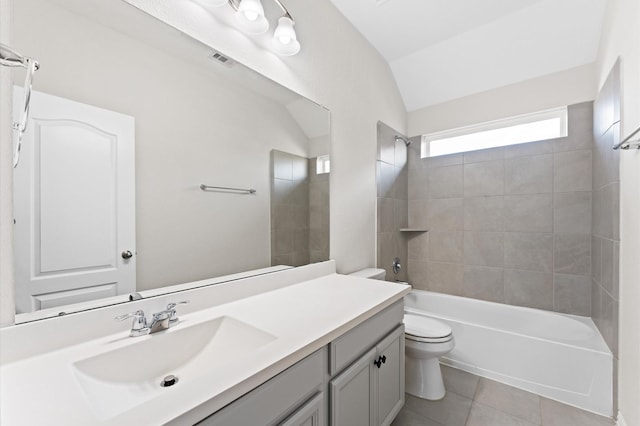 full bathroom with tile patterned flooring, lofted ceiling, toilet, vanity, and tiled shower / bath