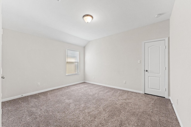 spare room with carpet and lofted ceiling