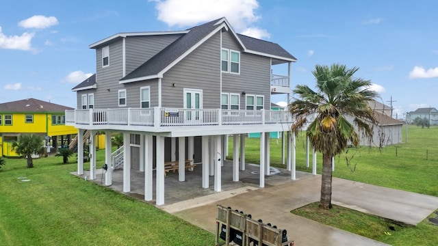 back of property featuring a wooden deck, a yard, and a carport