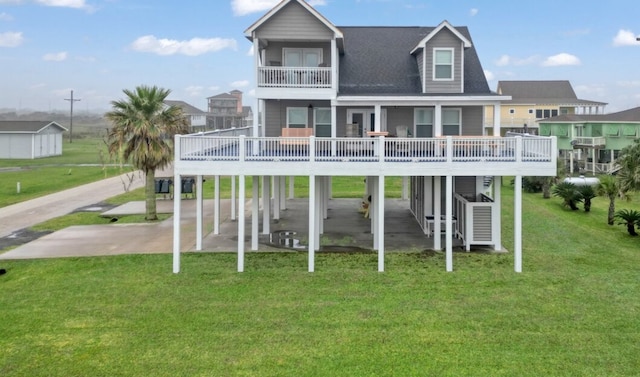 back of property with a carport and a yard