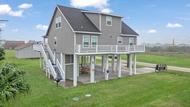 rear view of property featuring a yard, a patio area, and a wooden deck