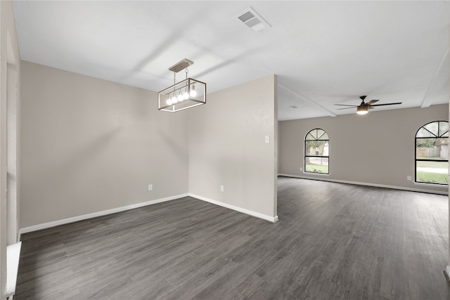 empty room featuring ceiling fan with notable chandelier and dark hardwood / wood-style floors