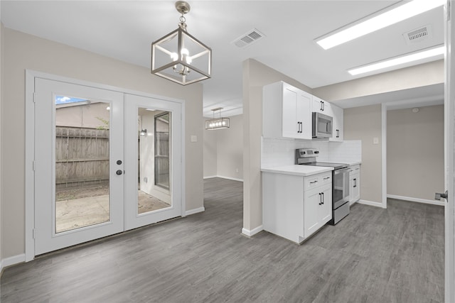 kitchen with light wood-type flooring, stainless steel appliances, white cabinetry, and hanging light fixtures