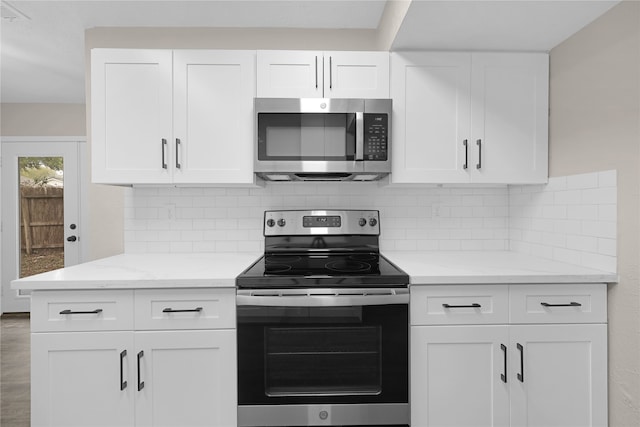 kitchen featuring white cabinetry, stainless steel appliances, and light stone counters