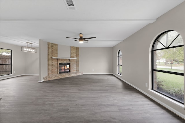 unfurnished living room with ceiling fan, wood-type flooring, and a fireplace