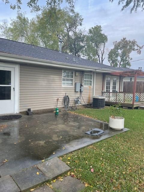 rear view of property with central AC, a lawn, and a wooden deck