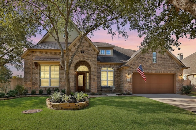 tudor home featuring a lawn and a garage