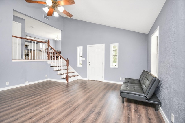 unfurnished room with ceiling fan with notable chandelier, dark wood-type flooring, and high vaulted ceiling