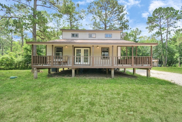 back of property featuring covered porch, french doors, and a yard