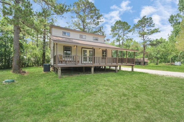 rear view of property featuring a porch, central air condition unit, and a lawn