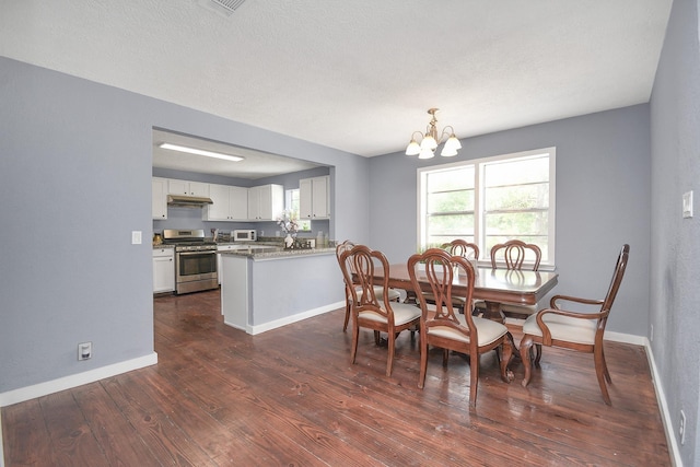 dining room featuring a chandelier, a textured ceiling, and dark hardwood / wood-style floors