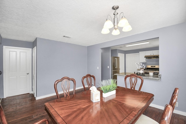 dining area with a textured ceiling, a notable chandelier, and dark wood-type flooring