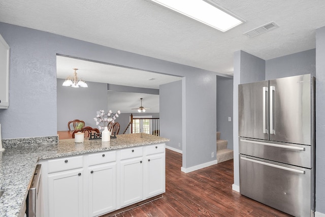 kitchen with stainless steel refrigerator, white cabinetry, kitchen peninsula, and dark hardwood / wood-style flooring