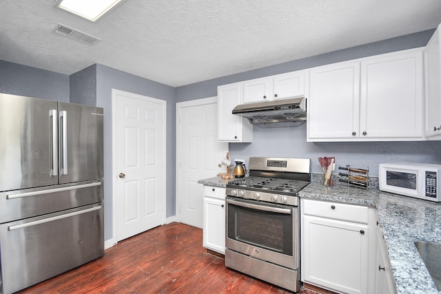 kitchen featuring white cabinets, appliances with stainless steel finishes, dark hardwood / wood-style floors, and light stone countertops