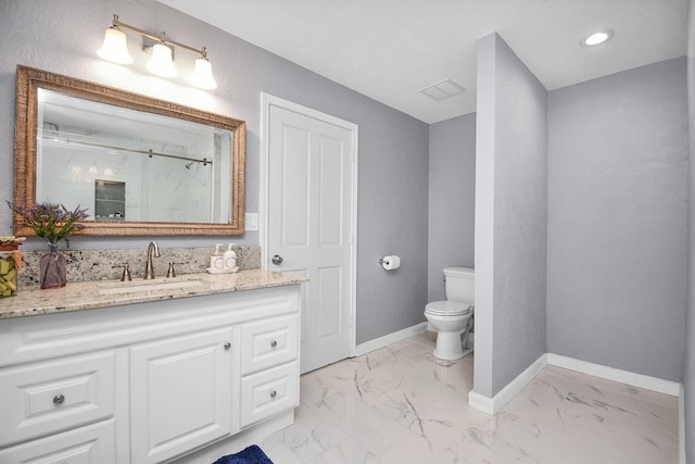 bathroom featuring vanity, toilet, and a shower with door