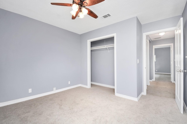 unfurnished bedroom featuring ceiling fan, light carpet, and a closet