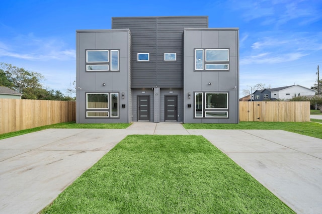 contemporary house featuring a front lawn and a garage