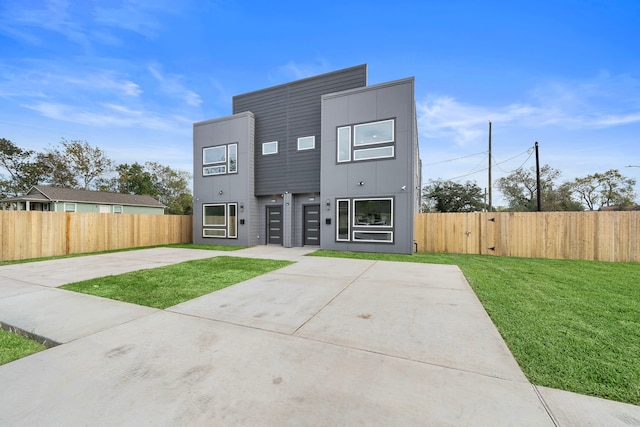 contemporary home featuring a patio and a front lawn