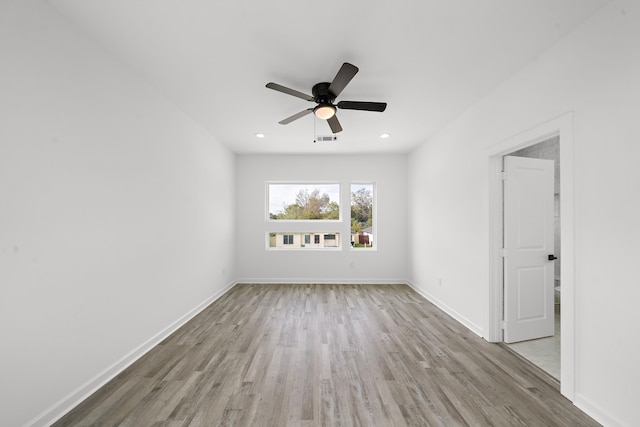 empty room with ceiling fan and light hardwood / wood-style floors