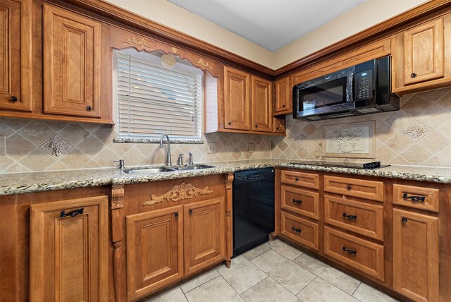 kitchen with sink, tasteful backsplash, light stone counters, and black appliances