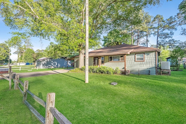 single story home with cooling unit, covered porch, and a front yard