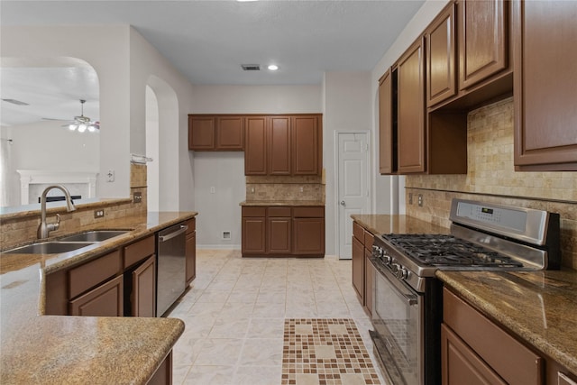 kitchen featuring light stone countertops, decorative backsplash, stainless steel appliances, sink, and light tile patterned floors