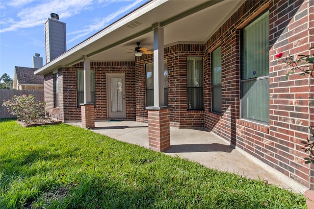 entrance to property with a yard and ceiling fan