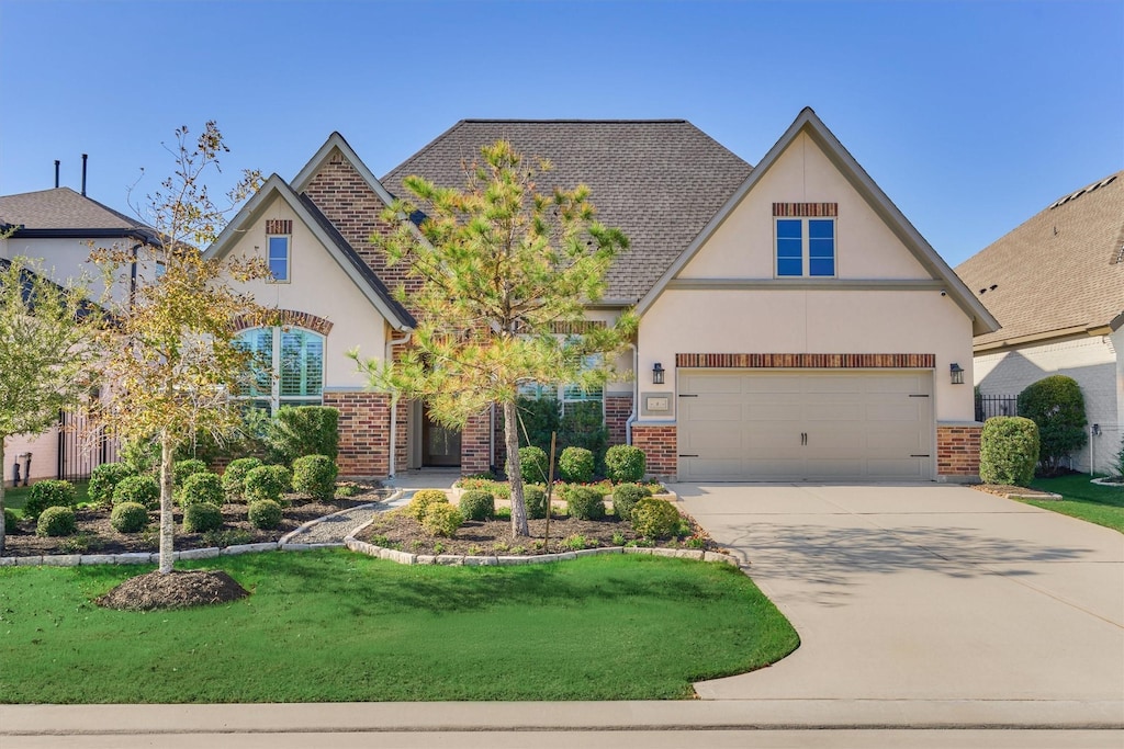 tudor-style house with a front yard and a garage