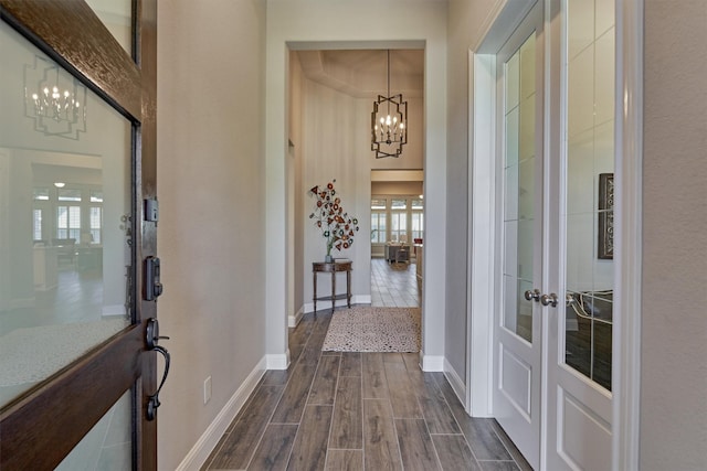 interior space featuring a chandelier, french doors, and dark hardwood / wood-style floors