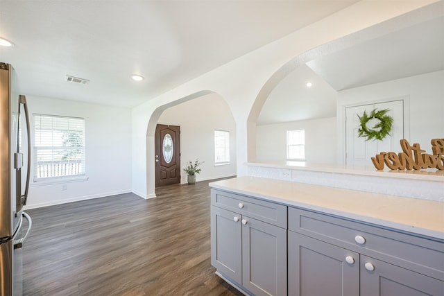 kitchen featuring stainless steel fridge, gray cabinets, and dark wood-type flooring