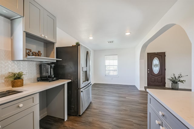 kitchen featuring gray cabinets, stainless steel fridge, dark hardwood / wood-style flooring, and decorative backsplash