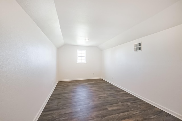 interior space with dark hardwood / wood-style flooring and vaulted ceiling