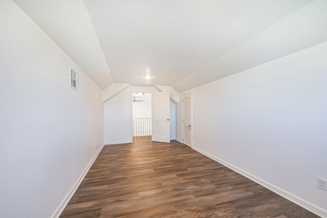 additional living space with ceiling fan, lofted ceiling, and dark wood-type flooring