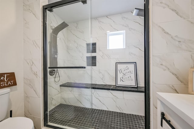 bathroom featuring toilet and a shower with shower door