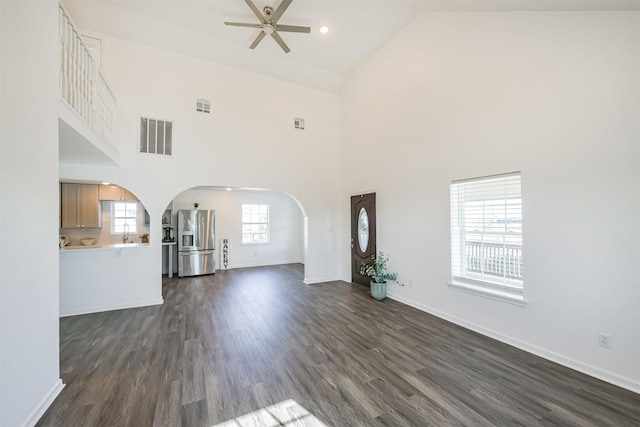 unfurnished living room featuring dark hardwood / wood-style floors, high vaulted ceiling, ceiling fan, and sink