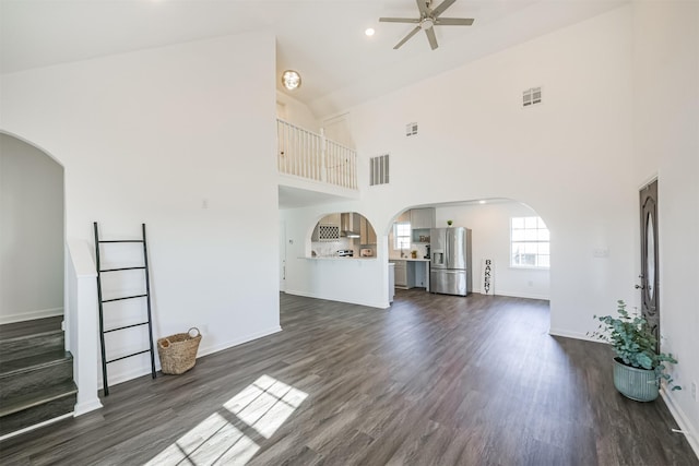 unfurnished living room with dark hardwood / wood-style flooring, high vaulted ceiling, and ceiling fan