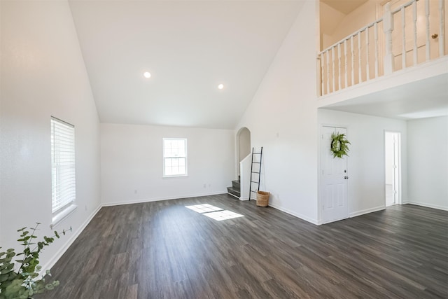 unfurnished living room featuring dark hardwood / wood-style flooring and high vaulted ceiling