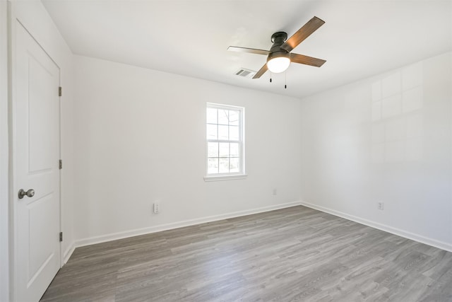 empty room with hardwood / wood-style floors and ceiling fan