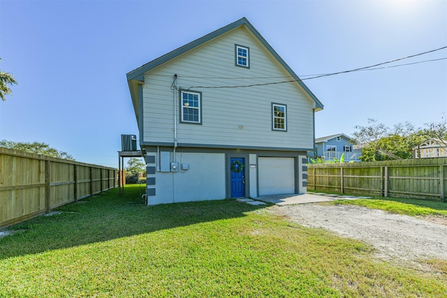 back of property featuring a garage and a yard