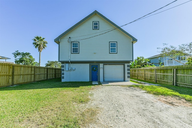 back of property with a garage and a yard