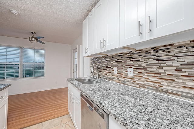 kitchen with stainless steel dishwasher, light hardwood / wood-style floors, white cabinets, and sink